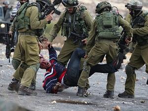 Israeli soldiers detain a Palestinian stone thrower near Beit El, on the outskirts of the West Bank city of Ramallah, on October 7, 2015. (AFP/ File Photo)