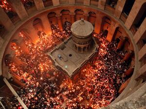 Christian Orthodox worshippers hold up candles lit from the “Holy Fire” as thousands gather in the Church of the Holy Sepulchre in Jerusalem’s Old City. (AFP/ File Photo)