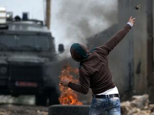 A Palestinian protester throws a stone towards Israeli security forces during clashes following a weekly demonstration against the expropriation of Palestinian land by Israel in the village of Kfar Qaddum, near Nablus, in the occupied West Bank on March 17, 2017. (AFP/Jaafar Ashtiyeh)