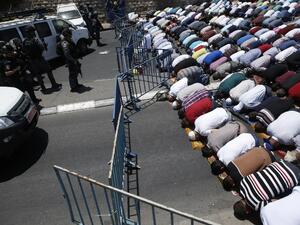 Muslim worshippers pray perform the traditional Friday prayers on a street outside the Lion Gate as Israeli police blocks the access to Al-Aqsa Mosque on July 14, 2017 (Ahmad Gharabli/AFP)