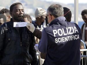A migrant is logged as he disembarks from a Maltese coast guard patrol vessel after being rescued at sea, on April 15, 2016, at the Messina harbor in Sicily. (AFP/Giovanni Isolino)