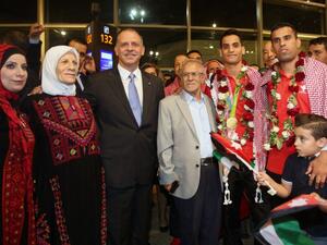 Jordanian Prince Faisal bin al-Hussein (3L) poses for a photo with Ahmed Abughaush (3R) who won the men's 68-kg taekwondo competition at the Olympics in Rio de Janeiro during a welcome ceremony upon his arrival at the Queen Alia International Airport in Amman on August 23, 2016. (AFP/Khalil Mazraawi)