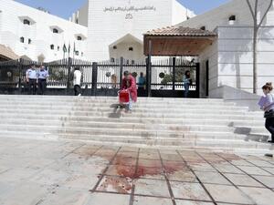 A man cleans the blood of prominent Jordanian writer Nahed Hattar after he was shot dead outside a court in Amman on Sept. 25, 2016, where he was facing charges for sharing a cartoon deemed offensive to Islam. (AFP/Ahmad Alalameen)