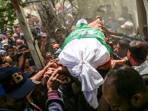 Mourners carry the body of 40-old Palestinian Jaber Abu Mustafa during his funeral/AFP
