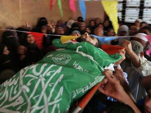 Mourners carry the body of Mohammed Dwedar a 27 year-old Palestinian, killed by Israeli fire along the Gaza border/AFP