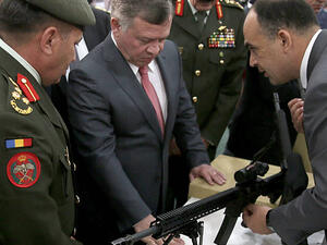 King Abdullah II of Jordan (C) checks a machine gun as he attends the Special Operations Forces Exhibition and Conference (SOFEX) in the Jordanian capital Amman. (AFP/ File Photo)