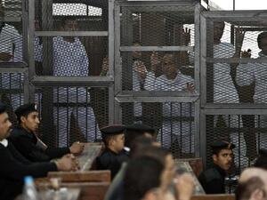 Journalists stand in the defendants' cage in a 2014 trial in Egypt. (AFP/File)