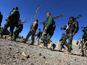 Kurdish and Yazidi fighters walk through Sinjar after reclaiming the town from Daesh. (AFP/Safin Hamed)