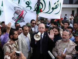 عبد الرحيم الكيب المكلف بتشكيل الحكومة الانتقالية يتوسط مجموعة من المقاتلين