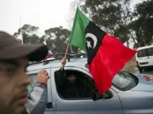  ليبيون يحملون علم المعارضة المناهضة لنظام القذافي