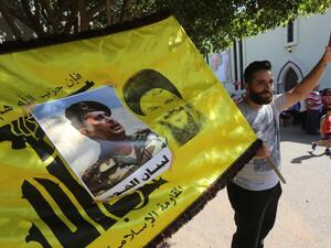 Supporters of Lebanon's Free Patriotic Movement celebrate the election of their leader MP Michel Aoun (portrait) and carry the flag of Hezbollah in the town of Jdeideh north of Beirut on October 31, 2016. (AFP/Marwan Tahtah)