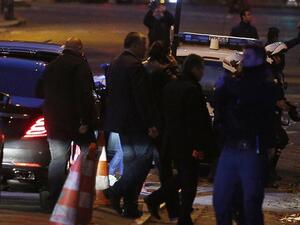 Lebanese Prime Minister Saad Hariri (C), surrounded by security personel, speaks on the phone as he arrives in Paris early November 18, 2017 (Geoffroy Van Der Hasselt/AFP)