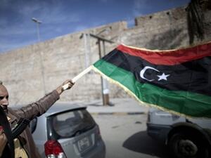 A man waves a Libyan flag in the midst of increasing conflict and dangers in Libya. (AFP/File)