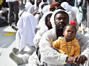 A father and daughter wait for aid distribution aboard a rescue ship, after their boat capsized off the coast of Libya. (AFP/Gabriel Bouys)