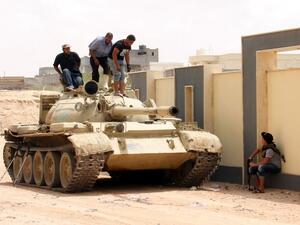 Forces with the National Unity Government stand on a tank in Sirte, Libya, during a land-and-air campaign to retake the city from Daesh. (AFP/Stringer)