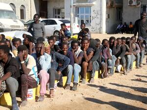 Migrants sit in a port in Tagiura, east of the Libyan capital Tripoli, after 137 people were rescued by coast guard boats off the coast of Libya on July 21, 2016. (AFP/Stringer)