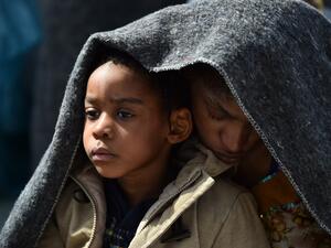 A woman and her daughter protect themselves with a blanket aboard the rescue ship "Aquarius", on May 25, 2016 a day after a rescue operation of migrants and refugees off the Libyan coast. (AFP/Gabriel Buoys)