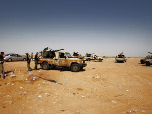 Militiamen serving Ibrahim al-Jathran (below) outside a Libya oil terminal after shutting it down in July. (AFP/ File)