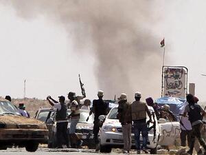 Libyan National Transitional Council fighters come under Grad missiles attack from Gaddafi loyalists at an outpost on the outskirts of the city of Bani Walid. (Joseph Eid/ AFP)