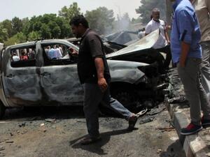 Men check the site of an explosion outside parliament's local building in al-Baida on 26 June. (AFP/File)