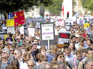 Demonstrators hold placards as they take part in a pro-refugee rally in central London. (AFP/FilePhoto)