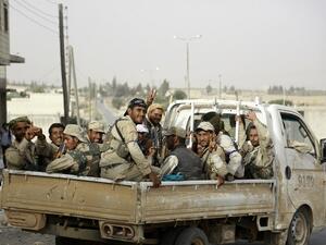 Fighters from Syria's Manbij military council sit on June 15, 2016 in the back of a pickup truck on the outskirts of the northern Syrian town of Manbij. (AFP/Souleiman)