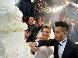 Mai and Oka cut their huge and delicious wedding cake. (Alwafd.org)