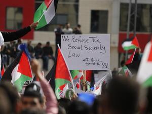 Palestinians wave national flags as they take part in a protest against a social security law proposed by the Palestinian Authority in the West Bank city of Ramallah on November 12, 2018. (ABBAS MOMANI / AFP)
 Palestinians wave national flags as they take part in a protest against a social security law proposed by the Palestinian Authority in the West Bank city of Ramallah on November 12, 2018. (ABBAS MOMANI / AFP)