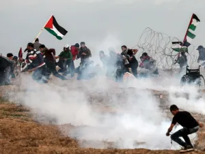 Palestinian demonstrators run for cover during a protest on November 16, 2018, on the eastern outskirts of Gaza City, near the border with Israel. (MAHMUD HAMS / AFP)
