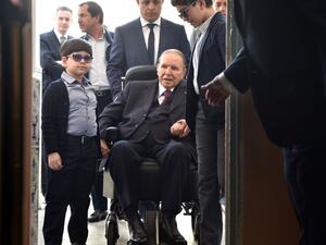 Algerian President Abdelaziz Bouteflika arrives on a wheelchair to vote at a polling station in Algiers. (RYAD KRAMDI / AFP)