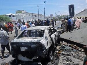 People stand at the site of a car bomb near a restaurant near the Somali ministry of internal security in Mogadishu on April 5, 2017. (AFP Photo)