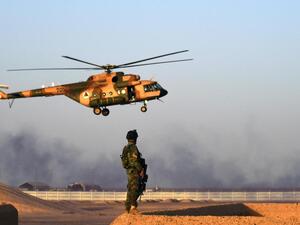 An Afghan Commandos stands guard while an Afghan Air Force helicopter flies past during a combat training exercise at the Shorab Military Camp in Helmand province. (AFP)