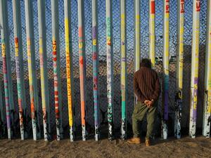  A man looks through the U.S.-Mexico border wall in the Las Playas area on January 6, 2019 in Tijuana, Mexico. (AFP/File)