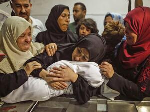 The body of a Palestinian baby who died of tear gas inhalation during protests, according to Gaza's health ministry, is held by her mother at a Gaza City morgue on May 15, 2018 (AFP /MAHMUD HAMS)