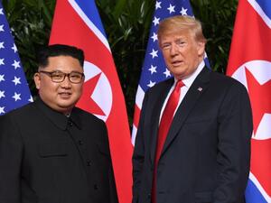 Standing in front of the flags of their two countries, Donald Trump and Kim Jong Un made history in Singapore (AFP /SAUL LOEB)