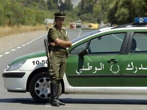 An Algerian policeman stands guard as security forces block the road to Lakhdaria. (AFP Photo/Fethi Belaid)
