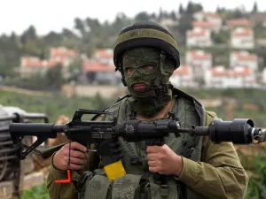 An Israeli soldier holds his weapon during clashes with Palestinian protesters in West Bank. (AFP Photo/Abbas Momani)
