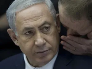 Israeli Prime Minister Benjamin Netanyahu listens to his spokesman Boaz Stambler. (AFP/File)