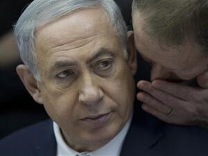Israeli Prime Minister Benjamin Netanyahu listens to his spokesman Boaz Stambler. (AFP/File)