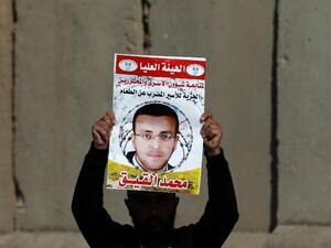 A Palestinian protester hold a poster with Mohammed al-Qiq's face. (AFP/Abbas Momani)