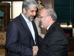 متقي يصافح زعيم حركة حماس، خالد مشعل، خلال زيارته الى دمشق مطلع الشهر/أ.ف.ب