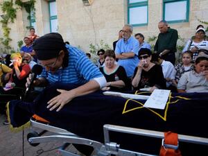Israeli Rina Yaffa Ariel, mourns over the body of her daughter Hallel, a 13-year-old girl who was fatally stabbed by a Palestinian attacker in her home, during her funeral in the Kiryat Arba settlement on June 30, 2016. (AFP/Gil Choen-Magen)