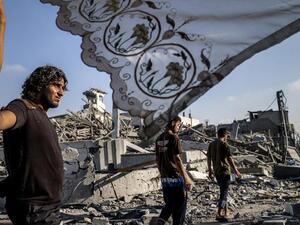 Palestinians stand next to a makeshift shelter in Gaza City on 6 August 2014. (AFP/File) Palestinians stand next to a makeshift shelter in Gaza City on 6 August 2014. (AFP/File)