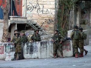 IDF soldiers stand guard near the site where a Palestinian attempted to stab a soldier. (AFP/File)