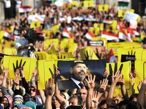 Supporters of the Egyptian Muslim Brotherhood gesture support for Morsi. (AFP/File)