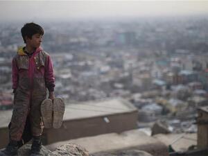 Afghan shoe-shine boy looks on from a hillside as he waits for customers in Kabul. (AFP/File)