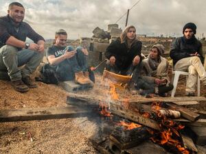 Israeli settlers gather around a fire in the settlement outpost of Amona. (AFP/File)