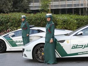 Emirati female police officers pose in front of Lamborghini (L) and Ferrari police vehicles. (AFP/File)