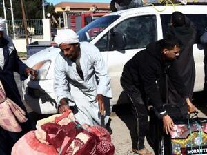 Egyptians gather their belongings as they prepare to cross to Tunisia, via the Libyan side of the Ras Djir border crossing, on February 23, 2015 for a flight evacuating them back to Cairo. (AFP/Mahmud Turkia)