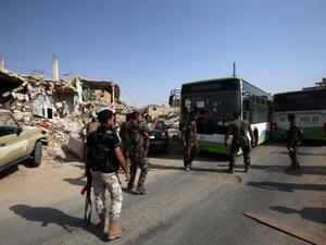 Syrian troops stand guard as a bus carrying people drives by, as part of an evacuation from the town of Daraya outside the capital Damascus on August 26, 2016 (AFP/Youssef Karwashan) Syrian troops stand guard as a bus carrying people drives by, as part of an evacuation from the town of Daraya outside the capital Damascus on August 26, 2016 (AFP/Youssef Karwashan)